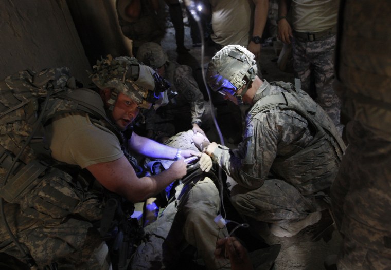 Image: A wounded U.S. soldier receives first aid inside a bunker in the village of Bargematal
