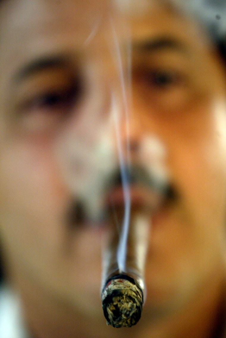 Image: A man smokes a cigar