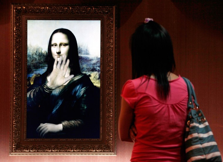 Image: A visitor looks at a three-dimensional, holographic version of the Mona Lisa portrait in Beijing