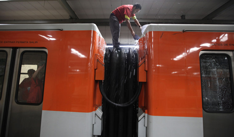 Image: cleaning crew scrubs cars of Mexico City's subway