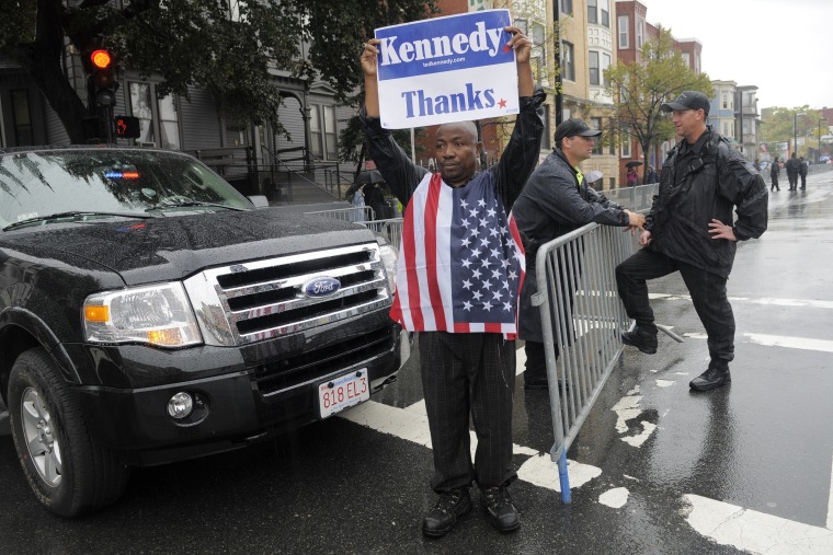 Image: Christopher Nzewwa, a native of Nigeria and longtime Boston resident, holds a sign thanking Senator Edward Kennedy