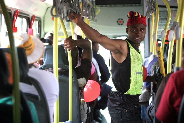 Image: A South African man holds on inside a Rea Vaya bus
