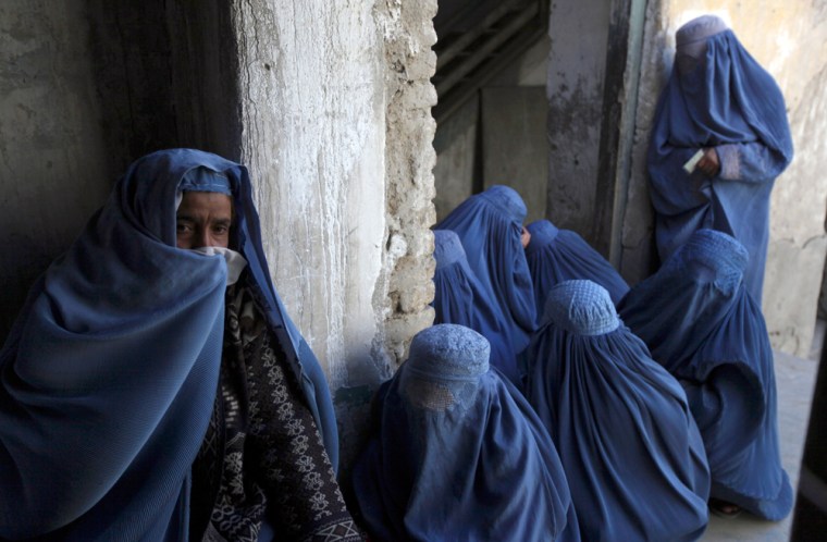 Image:  Women queue as they wait to cast their vote
