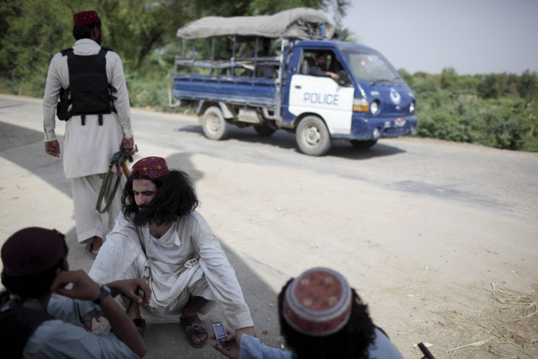 Image: Taliban fighters belonging to a pro-government faction chat on the street near their headquarters in Dera Ismail Khan