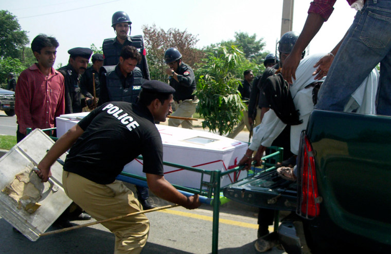 Image:Pakistani police officers load the dead body of Christian youth Fanish Masih