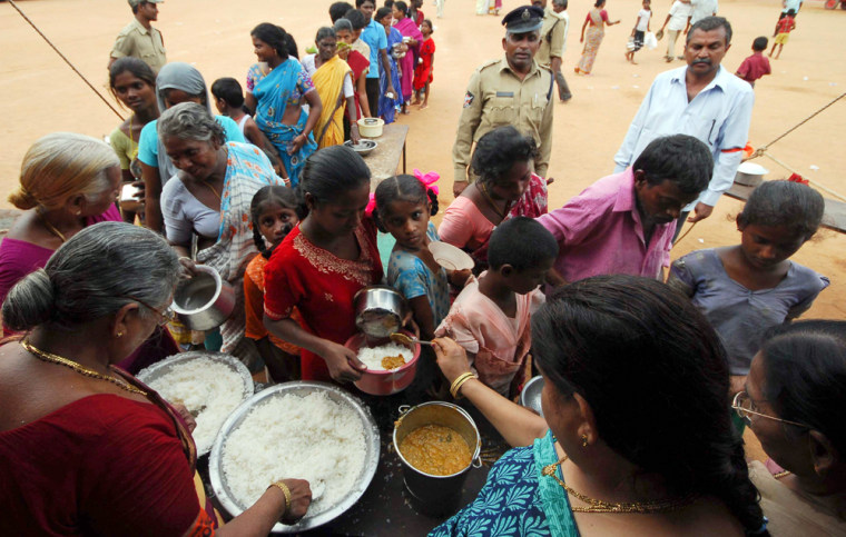 Image: flood victims wait for food