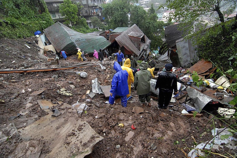 Image: Rescuers dig through mud in search of possible survivors
