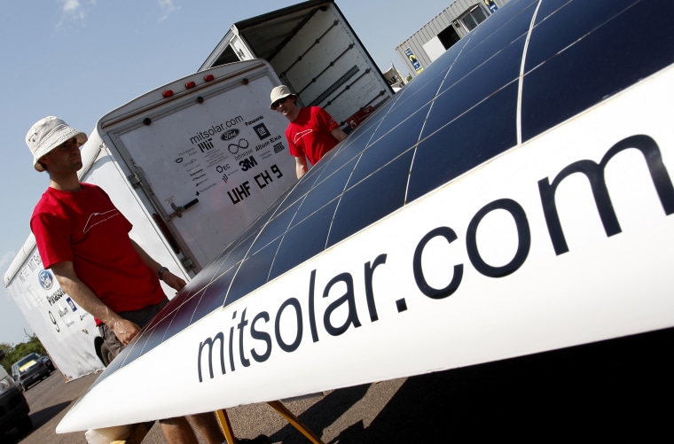 Image: Hayman hecks the solar panel of his vehicle after time trial in Darwin
