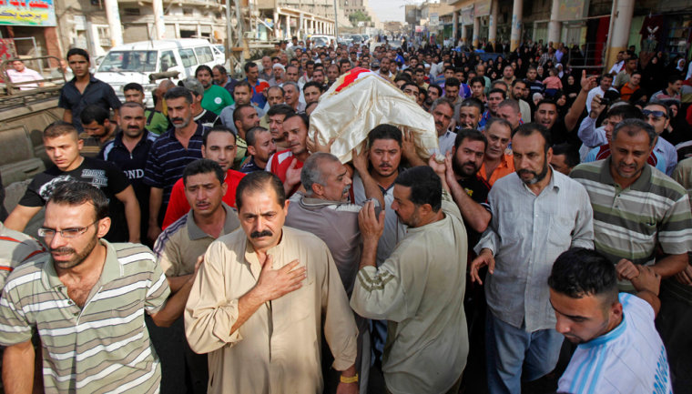 Image: Mourners carry the coffin a victim