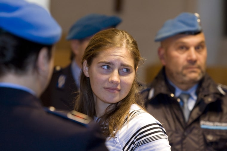 Image: Jailed suspect Amanda Knox is surrounded by penitentiary police as she arrives for a murder trial session in Perugia