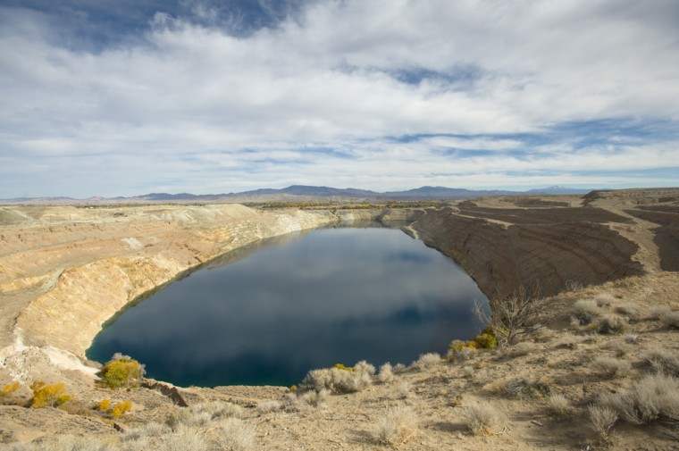 In this photo taken Oct. 26, 2009, the water filled mine pit at the former Anaconda copper mine site near Yearington, Nev. After decades of state and mine officials claiming that radiation and arsenic contamination in the local wells occurred naturally, scientists have mapped out a definitive uranium plume drifting from the mine site in the local groundwater. (AP Photo/Scott Sady)