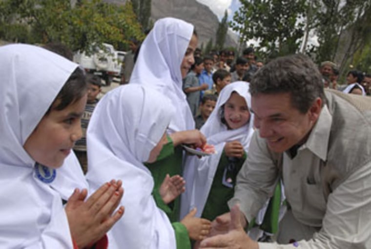 Greg Mortenson greets students at outside the village's school in Jafarabad in July, 2007.