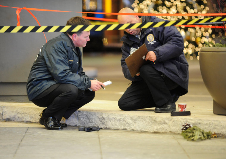 Image: Police officers inspect a crime scene