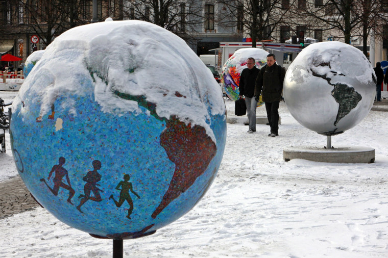 Image: People pass by globes in Copenhagen