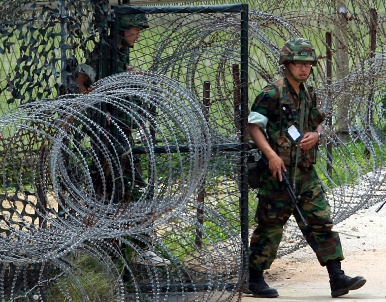 South Korean soldiers walk past barbed wire fence at watch post near demilitarized zone separating two Koreas in Paju