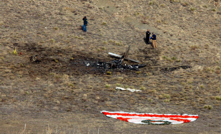 Image: Investigators survey the scene of a midair accident