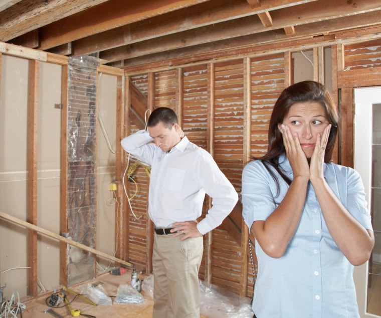 Couple stressed while standing in home repair