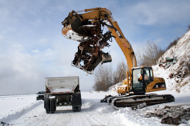 Image: A crane operator picks up an abandoned vehicle
