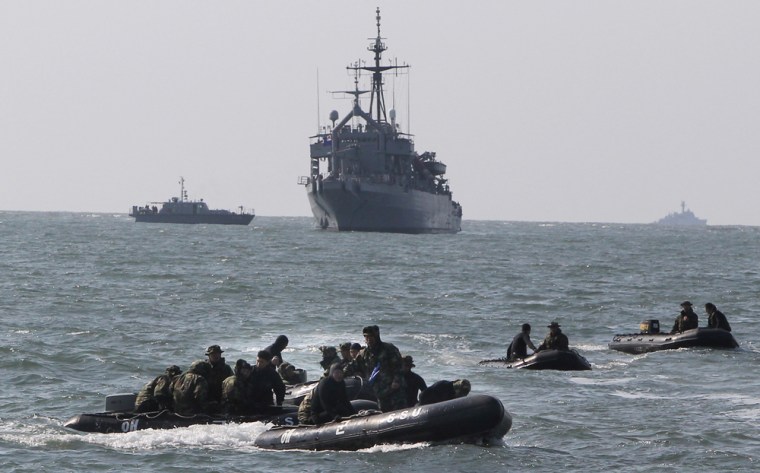 Image: South Korean Navy's Ship Salvage Unit members on rubber boats patrol to rescue possible survivors from a sunken naval ship