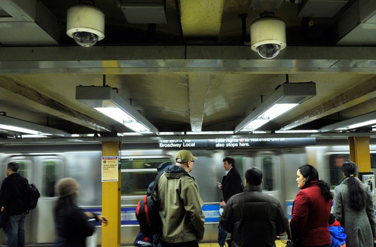 Image: Two ceiling-mounted video surveillance cameras are seen as a No. 1 subway train arrives at the 34th Street station