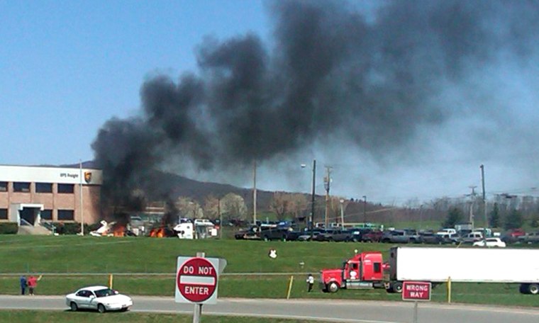 Image: Image: Smoke rises from the UPS building near the Roanoke Regional Woodrum Field Airport following a plane crash on Tuesday