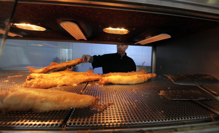 Image: Fried haddock are served at a Fish and Chip Takeaway in Manchester, north-west England,