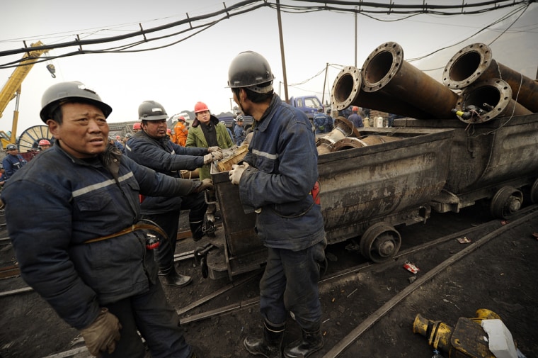 Image: Mine workers prepare to send equipment down the entrance to the Wangjialing coal mine