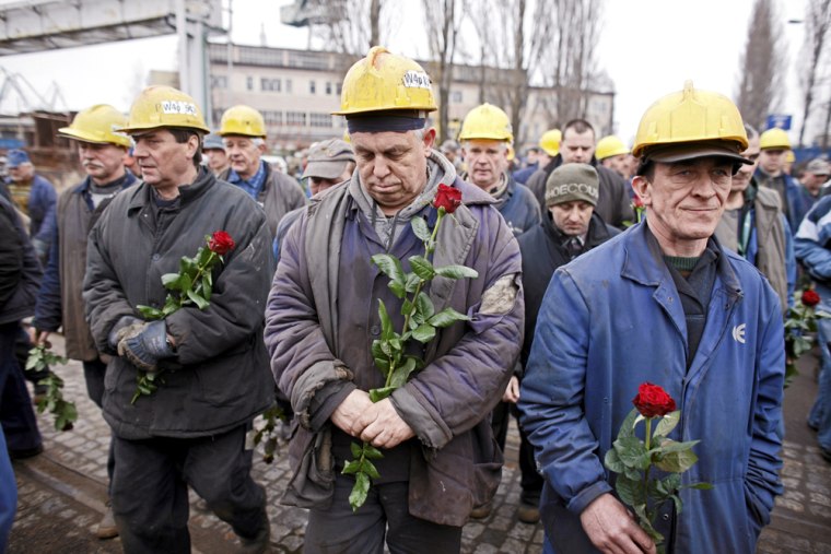 Image: Shipyard workers hold flowers