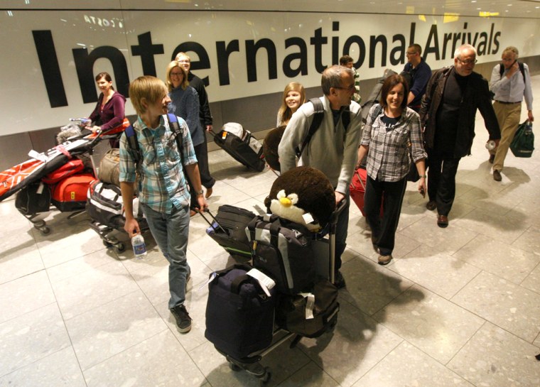 Image: Passengers arrive at London's Heathrow Airport after flying in on a British Airways flight from Vancouver,