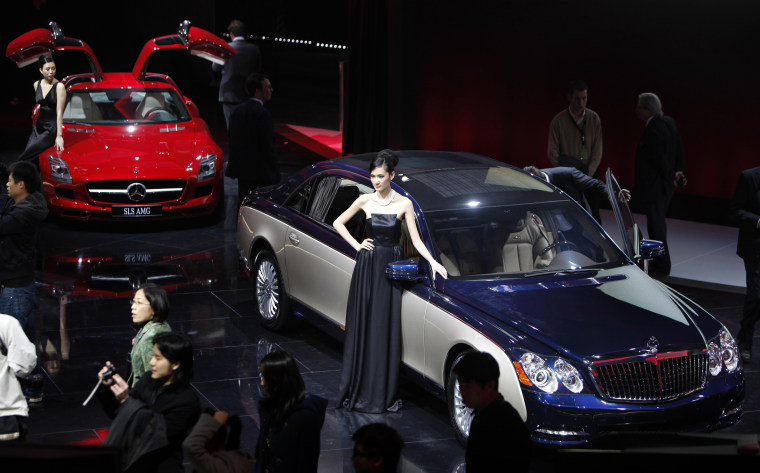 Image: Models stand next to a Daimler Maybach, right and Mercedes-Benz SLS
