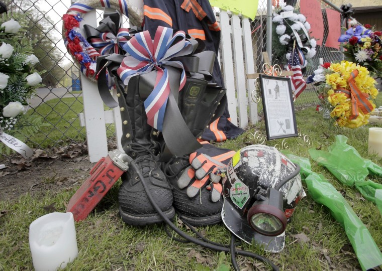 Image: A miner's boots, helmet and gloves appear in a make-shift memorial in Whitesville, W.Va.
