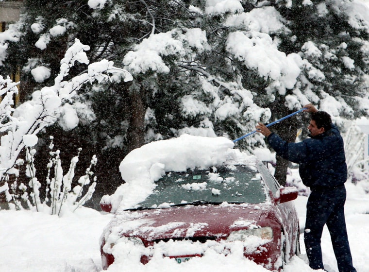 Image: Heriberto Perez Rios clears his car of snow