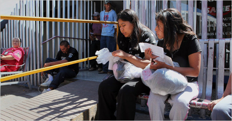 Image: Two women sat near the border with the United States in Nogales, Mexico, after being detained and deported by American border officials.