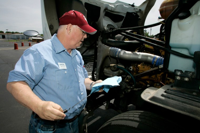 Image: Student Tommy Wood checks the oil in a training truck at Central Tech Truck Driver Training in Drumright, Okla.,