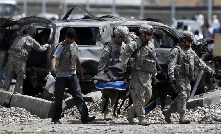 Image: U.S. soldiers carry a body at the site of a suicide car bombing in Kabul