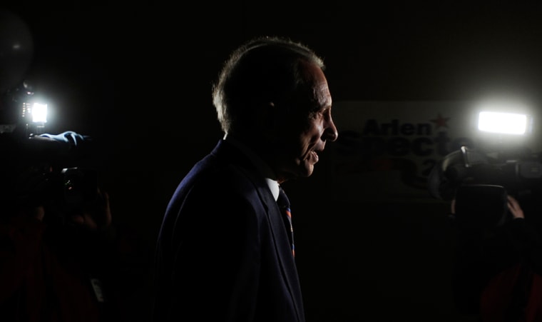 Image: Sen. Specter walks past television cameras following a news conference in Philadelphia