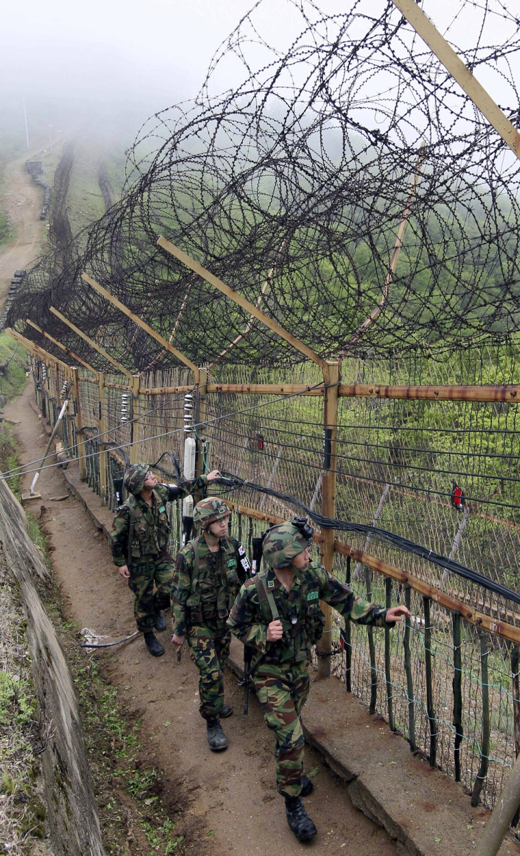 Image: South Korean soldiers check fences set up along the demilitarized zone