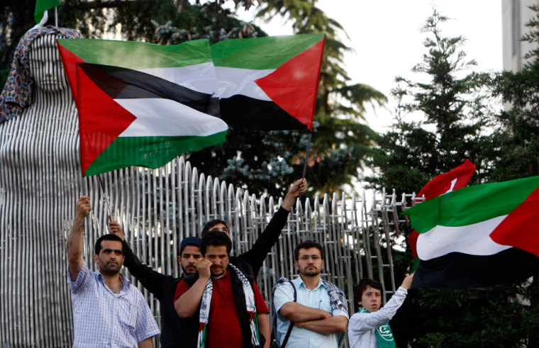 Image: Demonstrators holding Palestinian flags gather in front of the Israeli consulate in Istanbul
