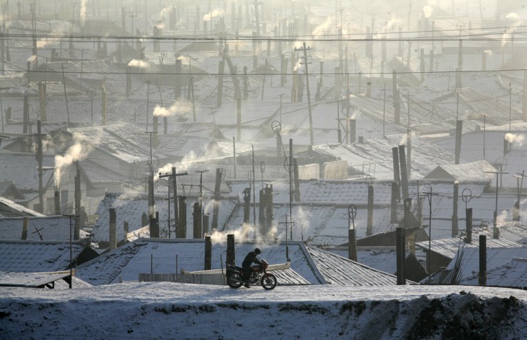 Image: A North Korean border guard rides his motorcycle on the banks of the Yalu river at the border with China near the North Korean city of Hyesan