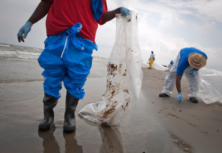 Image: Workers pick up tar balls from Deepwater Horizon oil leak, along beach in Grand Isle, Louisiana