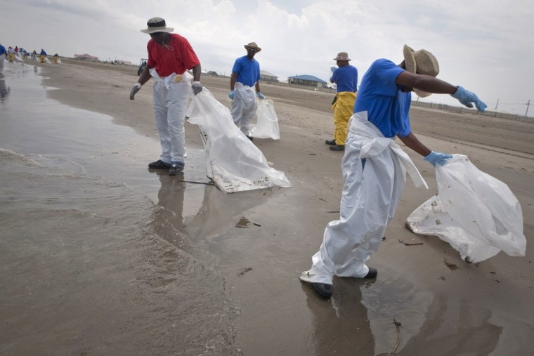 Image: BP workers pick up tar balls