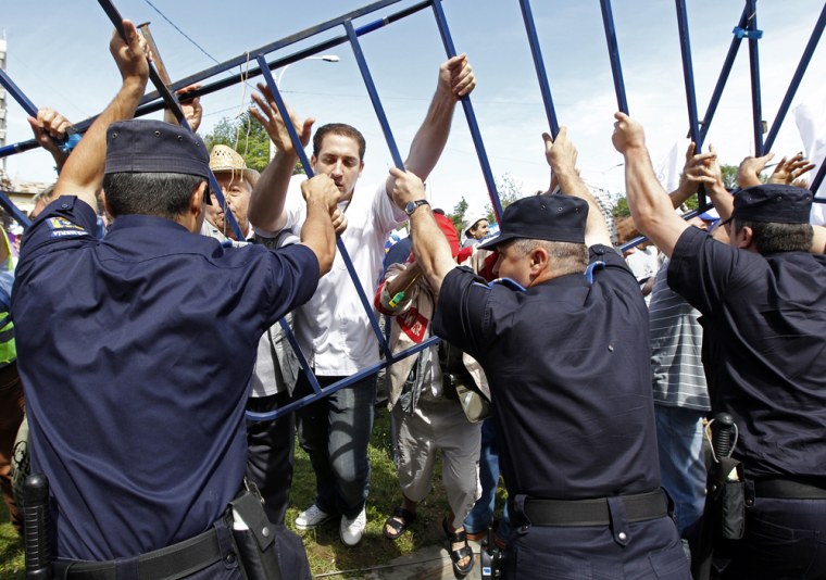 Image: Protesters clash with riot police in front of Romania's presidential palace in Bucharest
