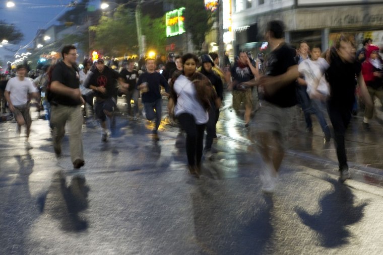 Image: Protesters run from police