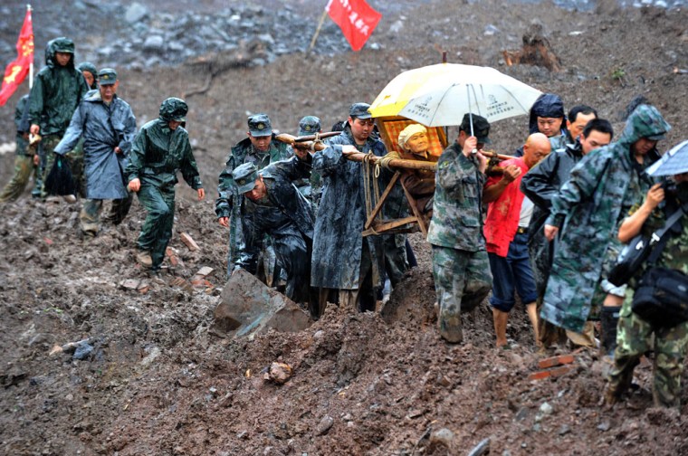 Image: Chinese soldiers evacuate residents from the site of a landslide