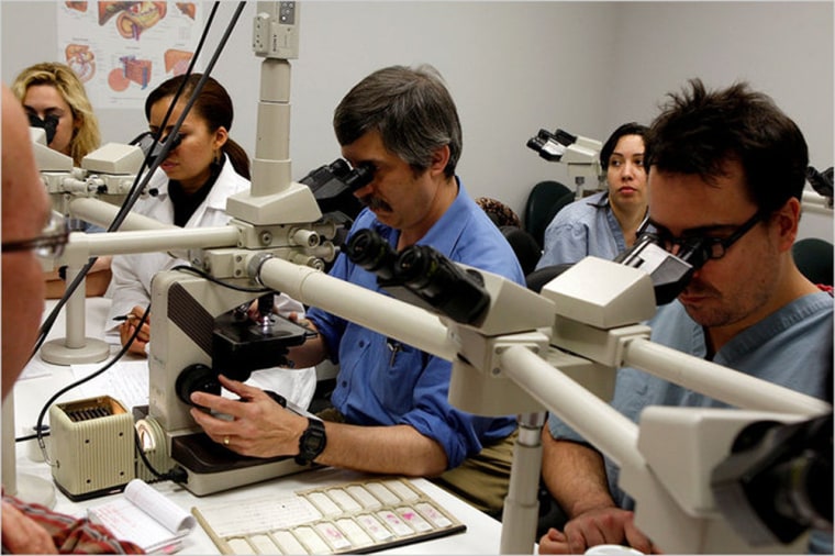 Image: Pathologists at Mount Sinai Medical Center in Manhattan examine slides of breast tissue.