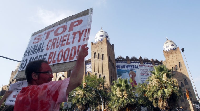 Image: A man holds a banner as he protests against bullfighting outside Barcelona's bullring before a festival in Barcelona