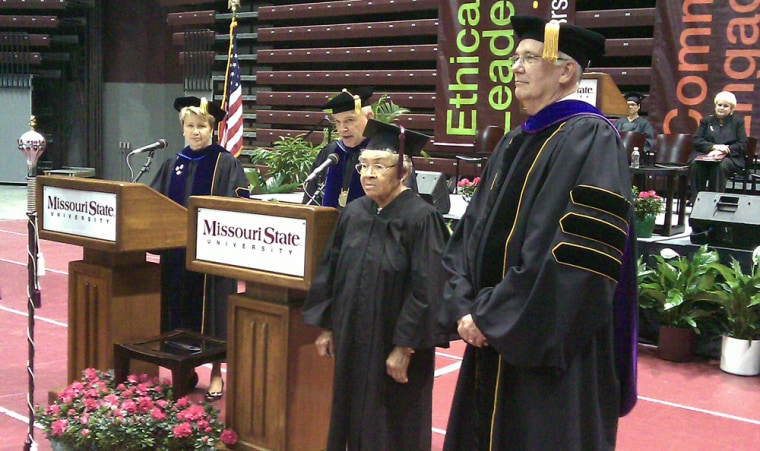 Mary Jean Price stands up on stage to receive her honorary undergraduate diploma during Missouri State University's summer commencement Friday afternoon. Earle Doman, vice president for student affairs at MSU, stands on the right.