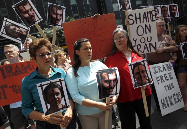Image: Fattal, Hickey and Shourd hold pictures of their children while protesting for their release with others outside the Iran Mission in New York