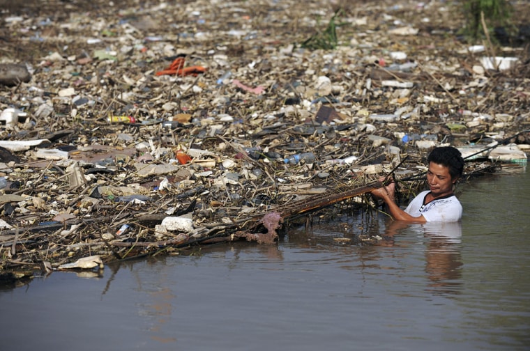 Image: A worker clears floating garbage in China