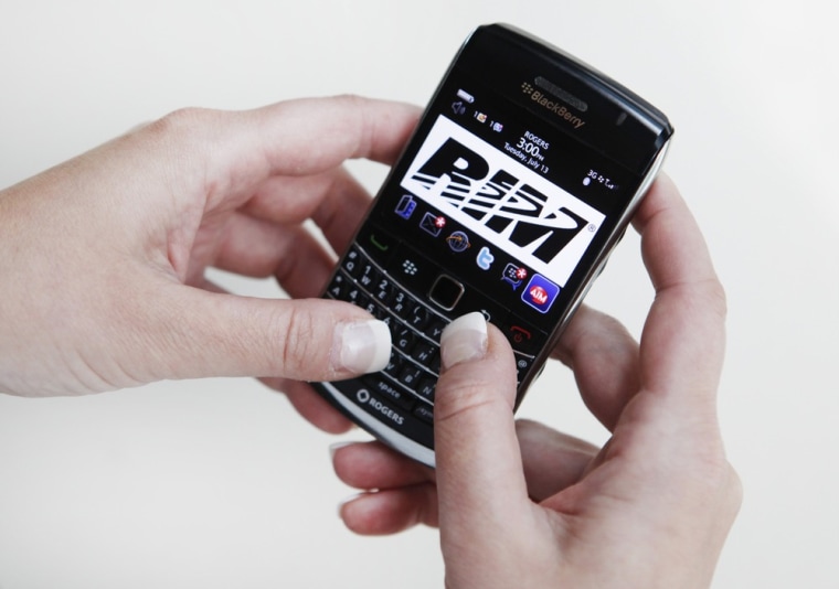 Image: A person poses while using a Blackberry Bold 2 smartphone